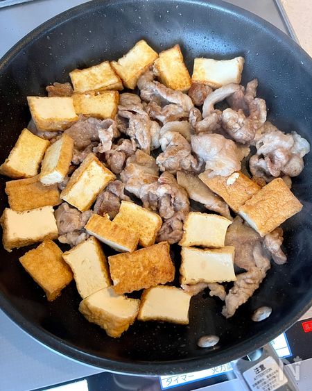 フライパンで豚こま肉と厚揚げを炒める