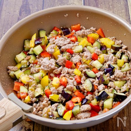 フライパンで豚ひき肉やカットした夏野菜を炒める