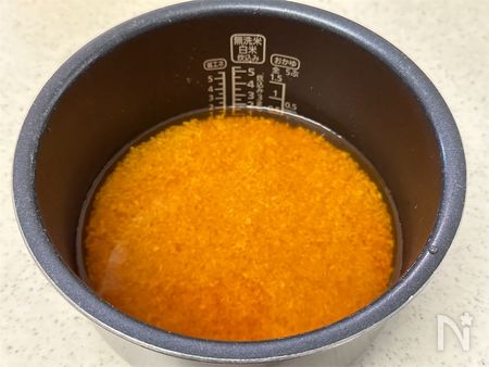 炊飯器の内釜に米と調味料、水を入れる