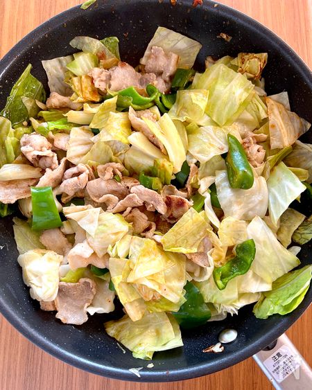 フライパンでキャベツとピーマン、豚バラ肉を炒める