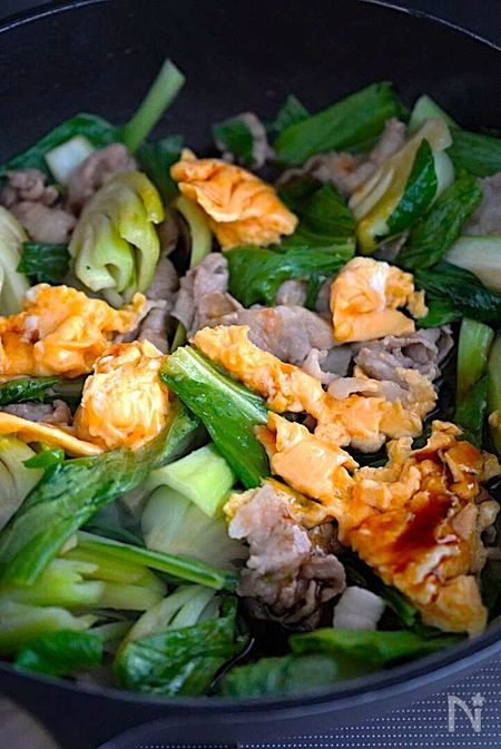 チンゲン菜の葉を炒め、調味料を加えて炒め合わせる