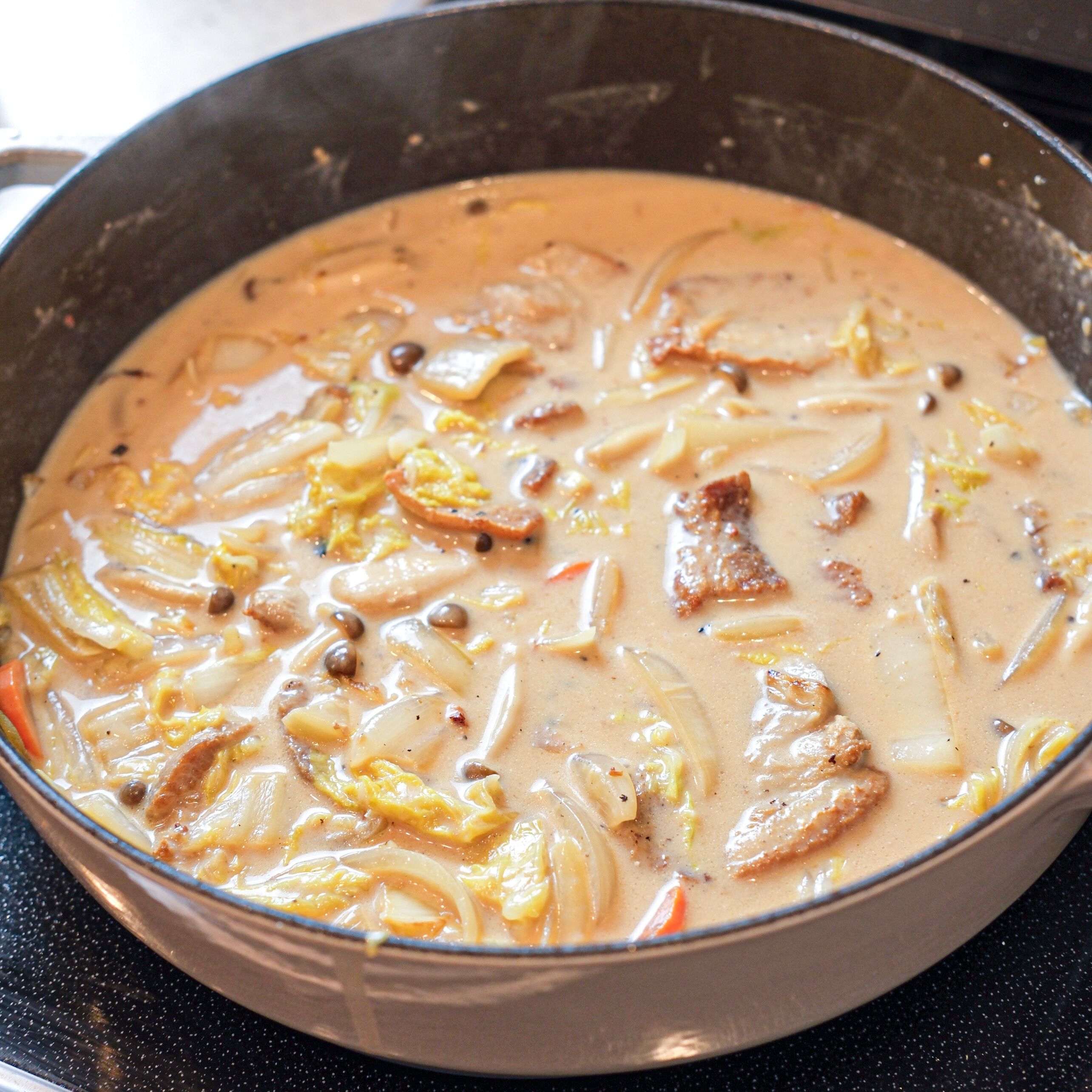 豚肉、水、牛乳、調味料を加えて煮る